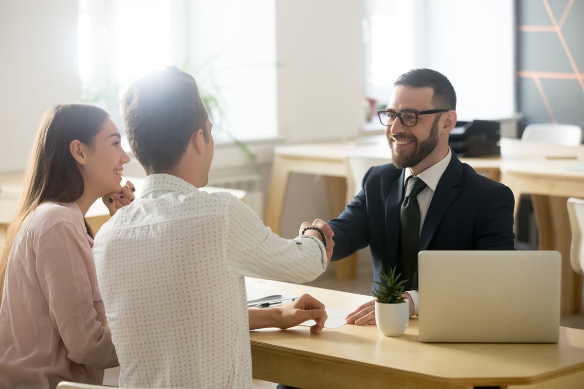 A couple shaking hands with a professional