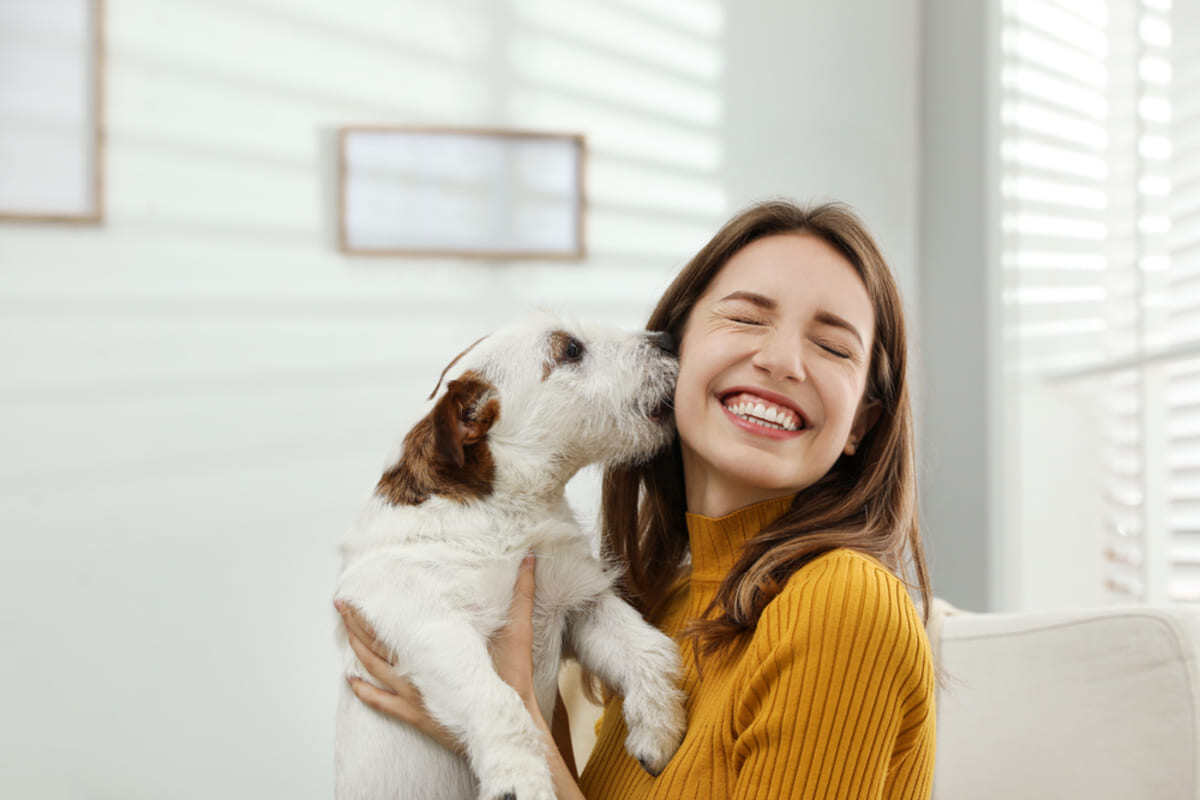 A happy tenant holding her dog, landlord pet policy concept