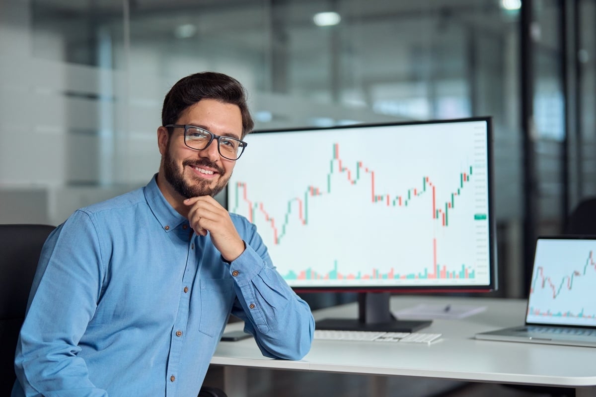 A man smiling in front of a graph